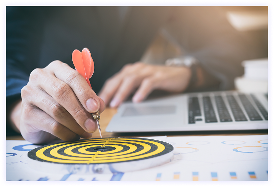 Hand placing dart on bullseye target with business charts
